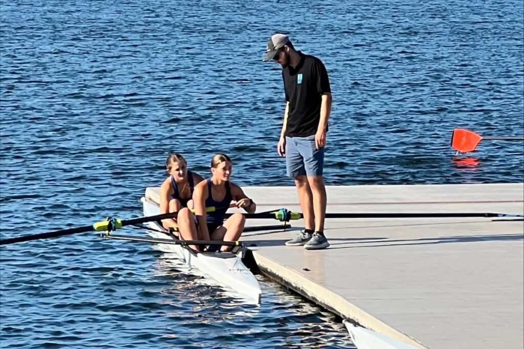 Gainesville Area Rowing team's Addie Matthews (back of boat) and Sophie Goldstein with coach Garrett Bauer.