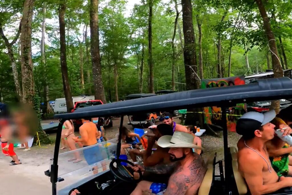 A woman, far left, flashes passing vehicles at Ginnie Springs during the 2024 Memorial Day weekend. Ginnie Springs Outdoors advised children to stay away during the weekend with its adult party atmosphere.