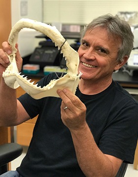 headshot of Gavin Naylor holding a shark jaw.