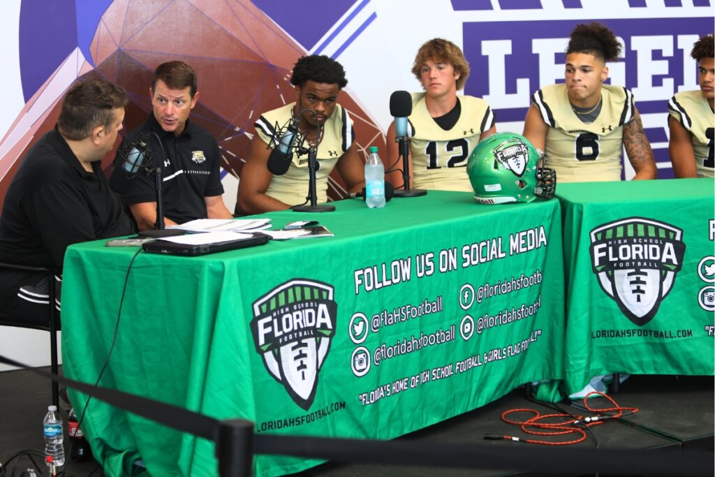 Buchholz football coach Mark Whittemore (second from left) talks to Marty Pallman at the 2024 North Central Florida High School Media Day.