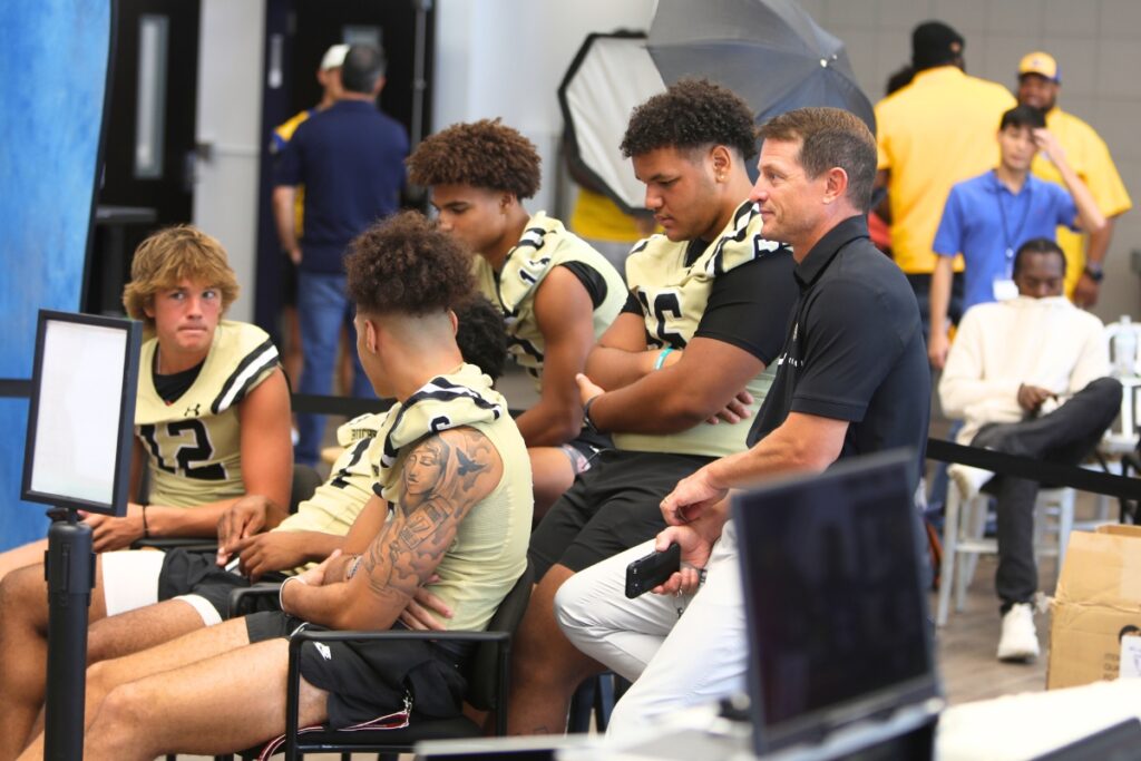 Buchholz players and coach Mark Whittemore wait to be interviewed at the 2024 North Central Florida High School Media Day on Wednesday.