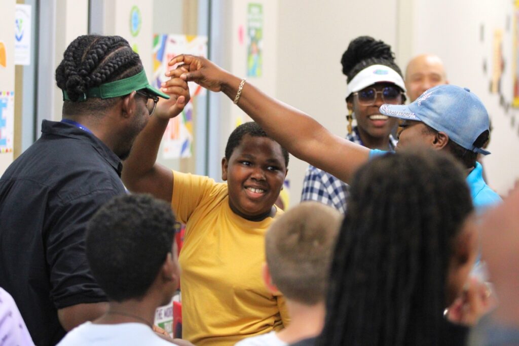 Instructor Thacher Loutin spins scholar Damien Sheppard as the school sings happy birthday.