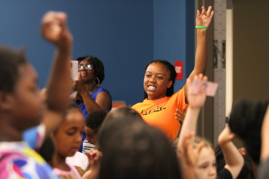 Site Coordinator K'Lor Simms participates in the morning Harambee with scholars.