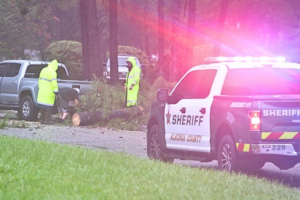 Alachua County Sheriff's deputies help with a downed tree going into a subdivision on SW 45th Place off Tower Road on Monday morning.