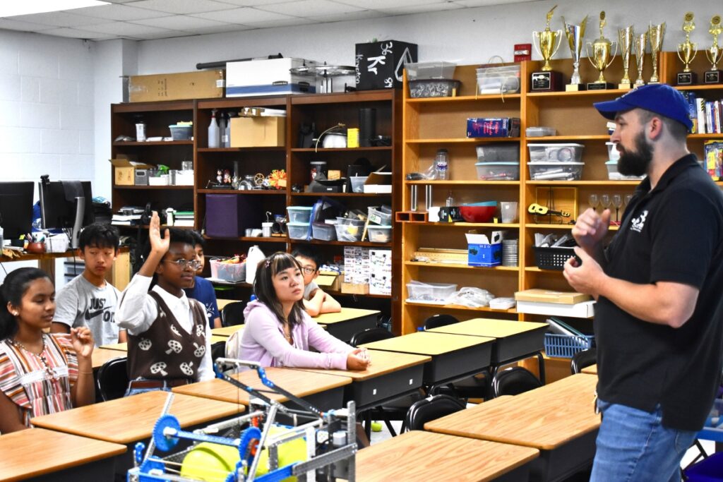 Students raise their hands in Marc Moody's first period AP physics class.