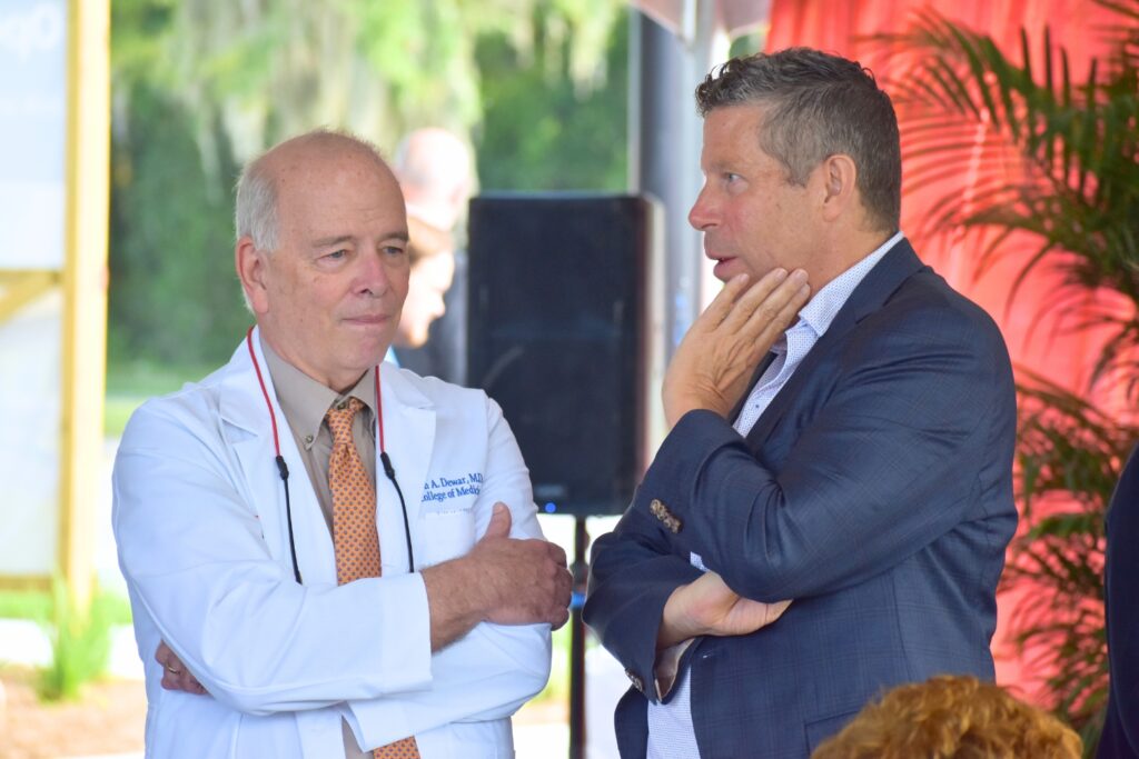 UF Health's Marvin Dewar (left) and David Nelson talk at the ribbon cutting ceremony.