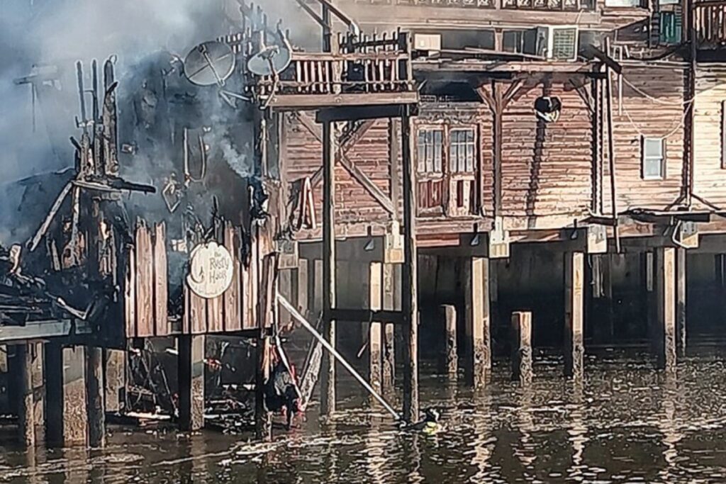 A firefighter battles a blaze on Dock Street in Cedar Key that damaged or destroyed multiple businesses on Thursday morning.
