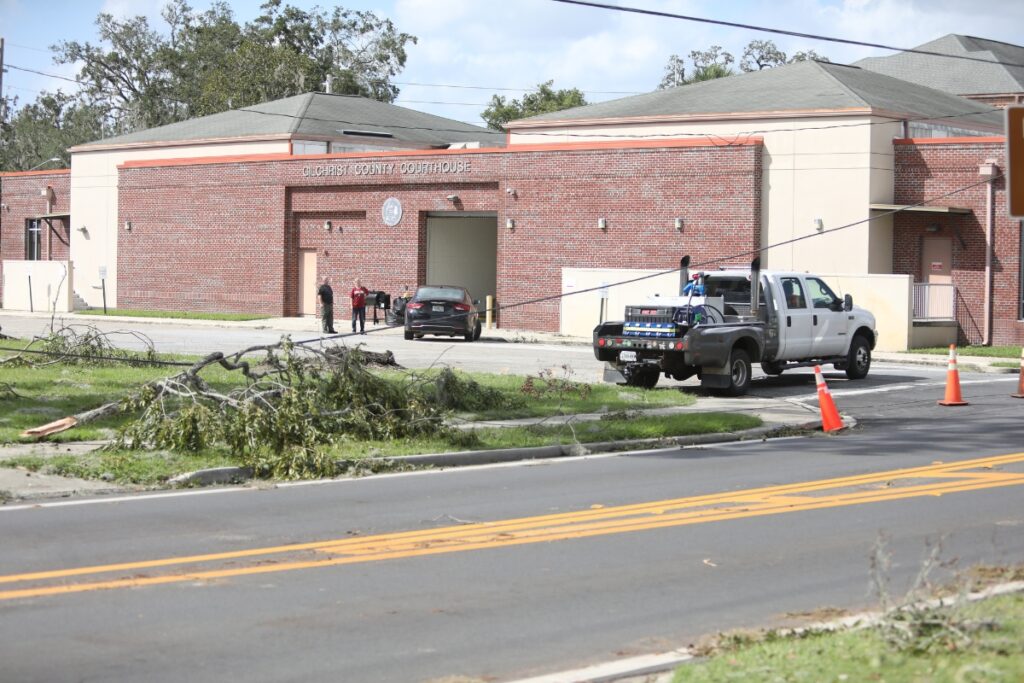 A tree limb brought blown down by Hurricane Helene draped over a power line next to the Gilchrist County Courthouse in Trenton on Friday morning.