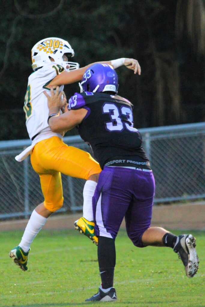 Gainesville's Nick Tisher shoves the Lecanto quarterback on a throw.