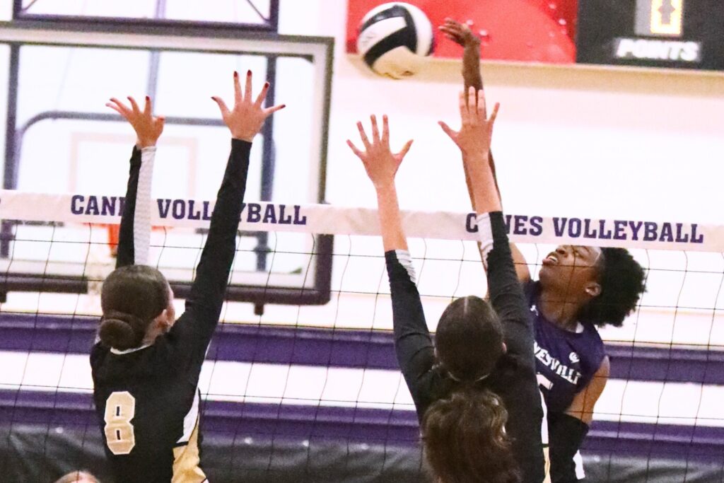 Gainesville's Nicole Ellis with a hit against Buchholz's Victoria Trucco (8) and Lillian Logan (3) on Monday.