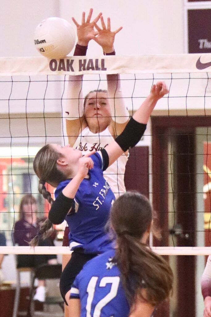 Oak Hall's Kendylle Bishop (14) blocks a hit from St. Francis Catholic Academy's Gabby Rosado on Tuesday.