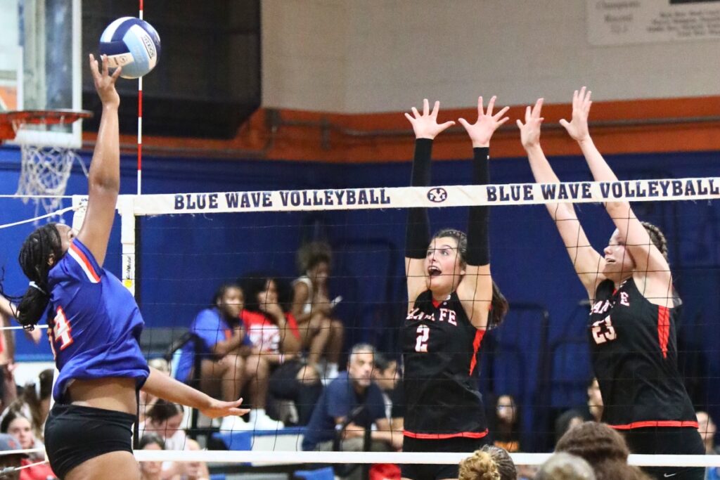 P.K. Yonge's Ajha Grady (14) with a hit against Santa Fe's Emarie Carlisle (2) and Alexis Rhode (23) on Thursday.