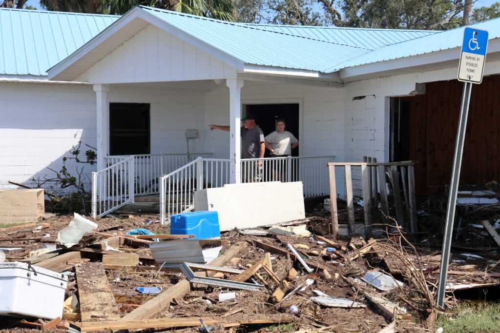 Jack Cook and his daughter Ashley Gregory inspect damage to the outside of First Baptist Church Horseshoe in Horseshoe Beach, Fla., on Friday. Cook said his grandson was the youngest member and joined the church two weeks prior to Helene's landfall. 