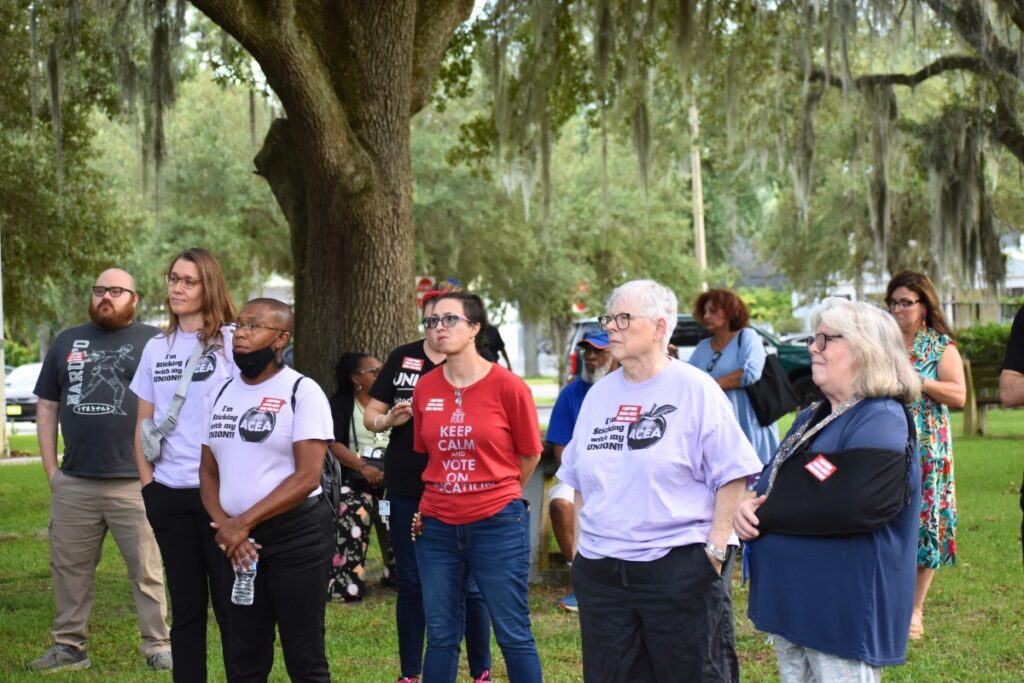 Teachers listen at the ACEA gathering on Tuesday, standing in solidarity with their union's declaration of an impasse during contract negotiations.