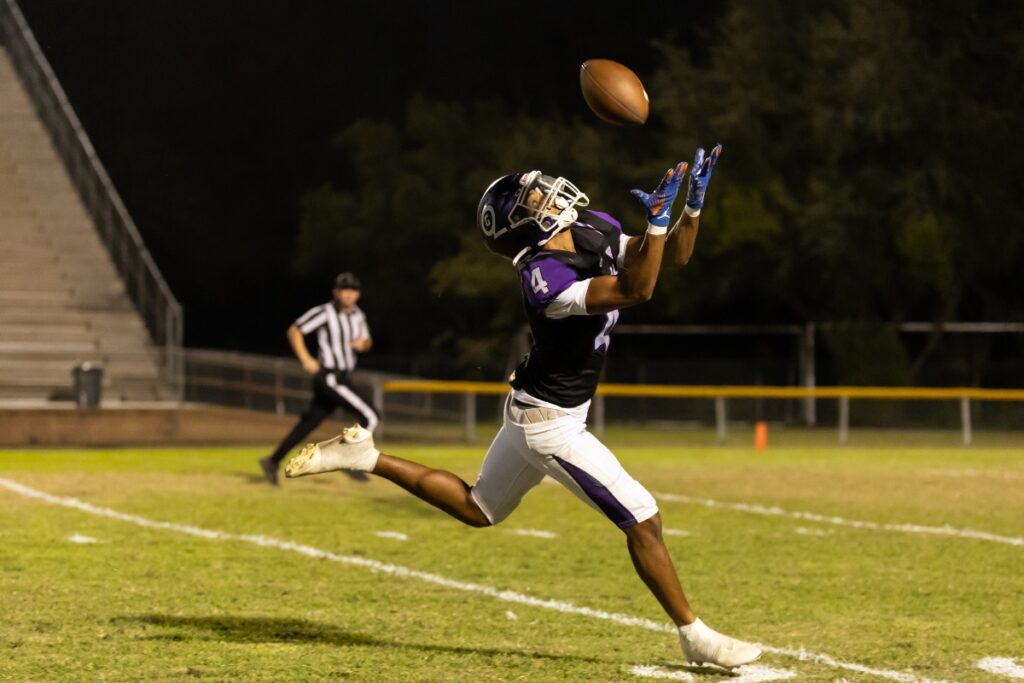 Gainesville's Calvin Thomas (4) attempts an over the shoulder catch against Lake Weir (Ocala).