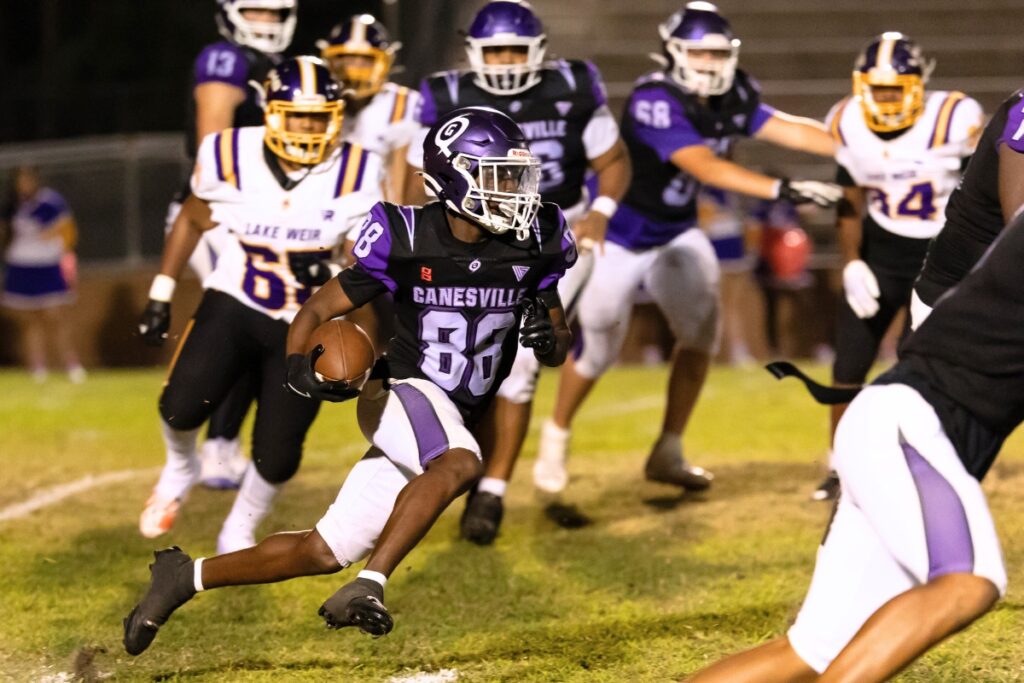 Gainesville's Camron Burse (88) carries the ball against Lake Weir (Ocala).