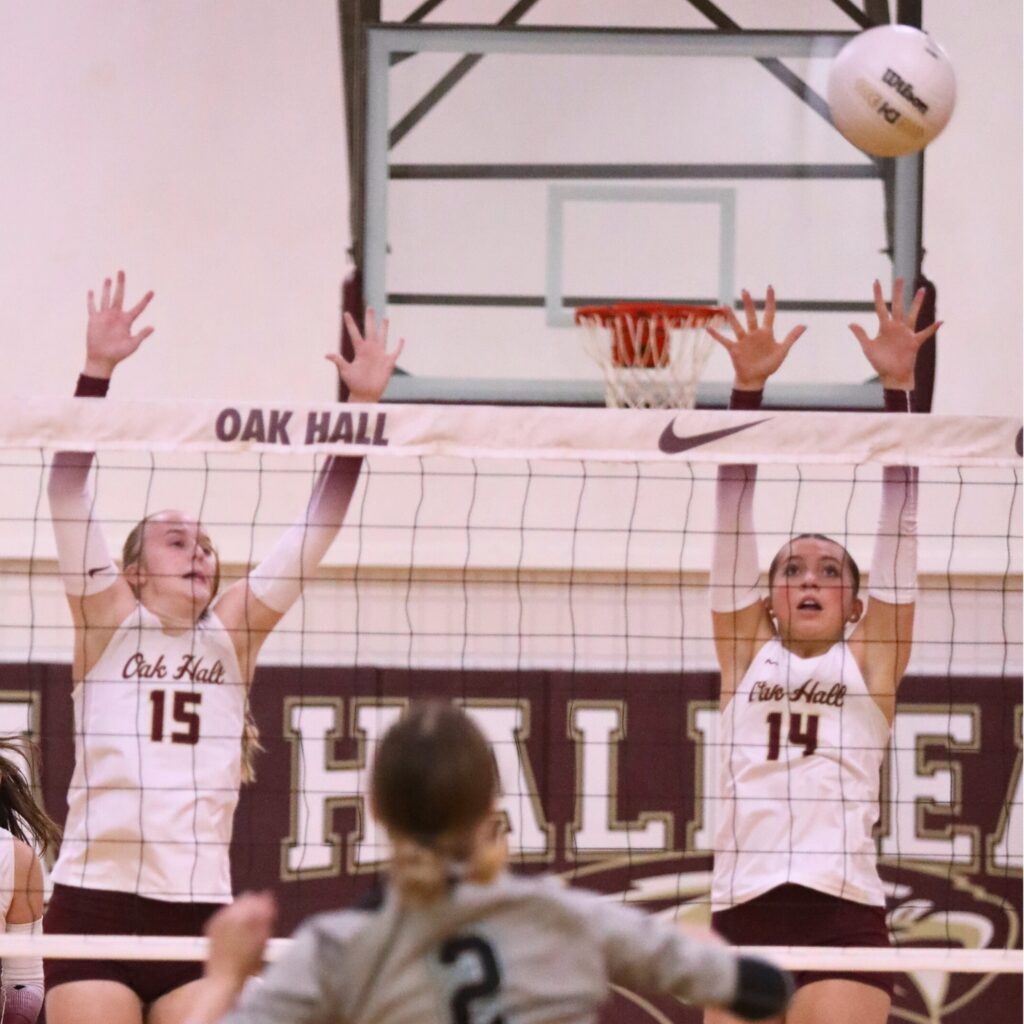 Oak Hall's Emma Raulerson (15) and Kendylle Bishop (14) go for a block against Providence (Jacksonville) in the Class 2A-Region 1 Quarterfinals.