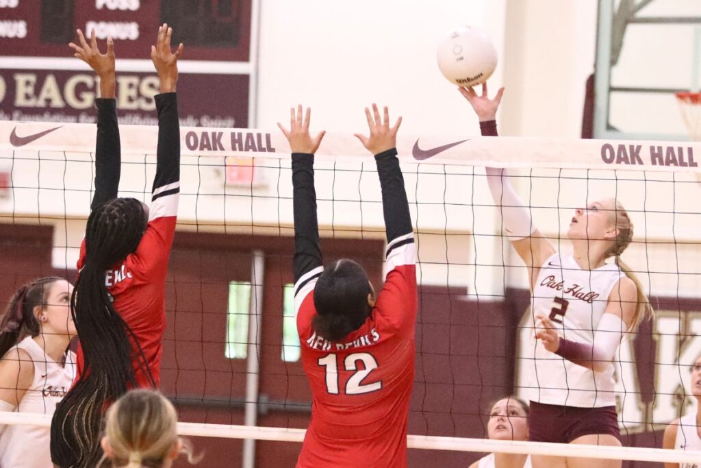 Oak Hall's Lizzie Cannon (2) with a hit against Williston's Destiny Ford (6) and Julissa Thomas (12) on Tuesday.