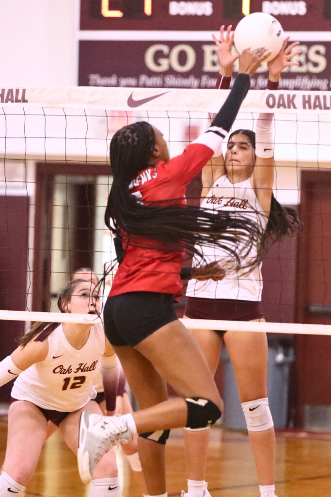 Williston's Destiny Ford (6) with a hit against Oak Hall's Shyla Akri (5) on Tuesday.