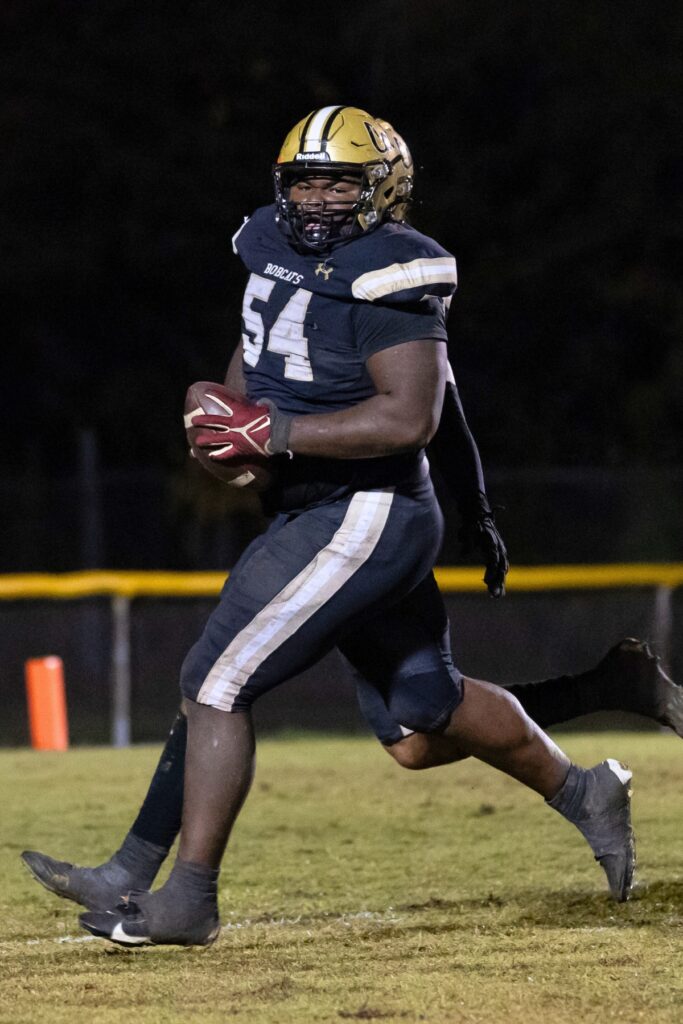 Buchholz's Elijah Daniels (54) picks up a loose ball on defense and returns it for a touchdown against Oakleaf.