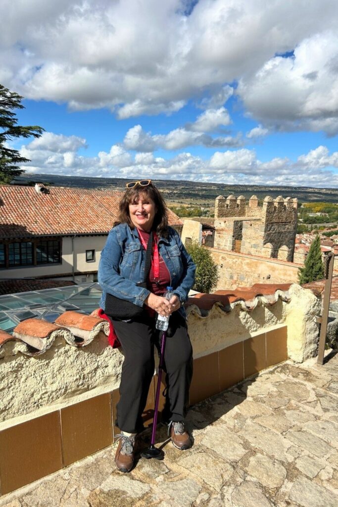 Correspondent Ronnie Lovler sits atop a section of the medieval wall still standing in Avila, Spain.