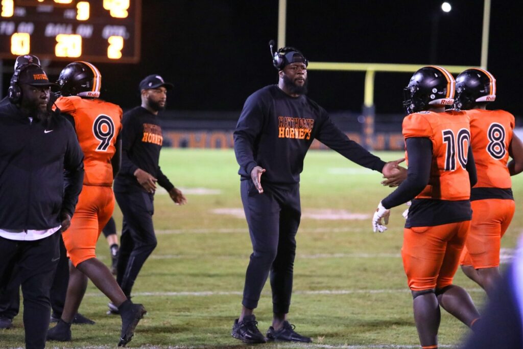 Hawthorne head coach Cornelius Ingram congratulates players coming off the field after the Hornets went up 42-0 in the second quarter over Branford.
