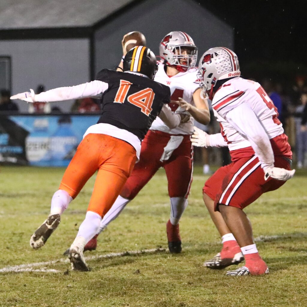 Hawthorne's Ethan Thomas (14) zeroes in on Williston's John Jazikoff (14) for a second-quarter sack.