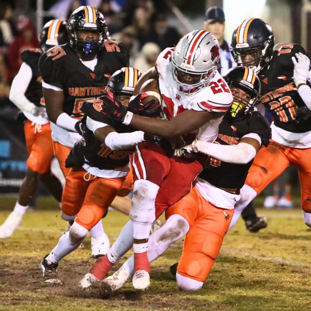 Hawthorne's Leland Johnson (1) and Kamari Debose (18) bring down Williston's Jamari Williams (22).