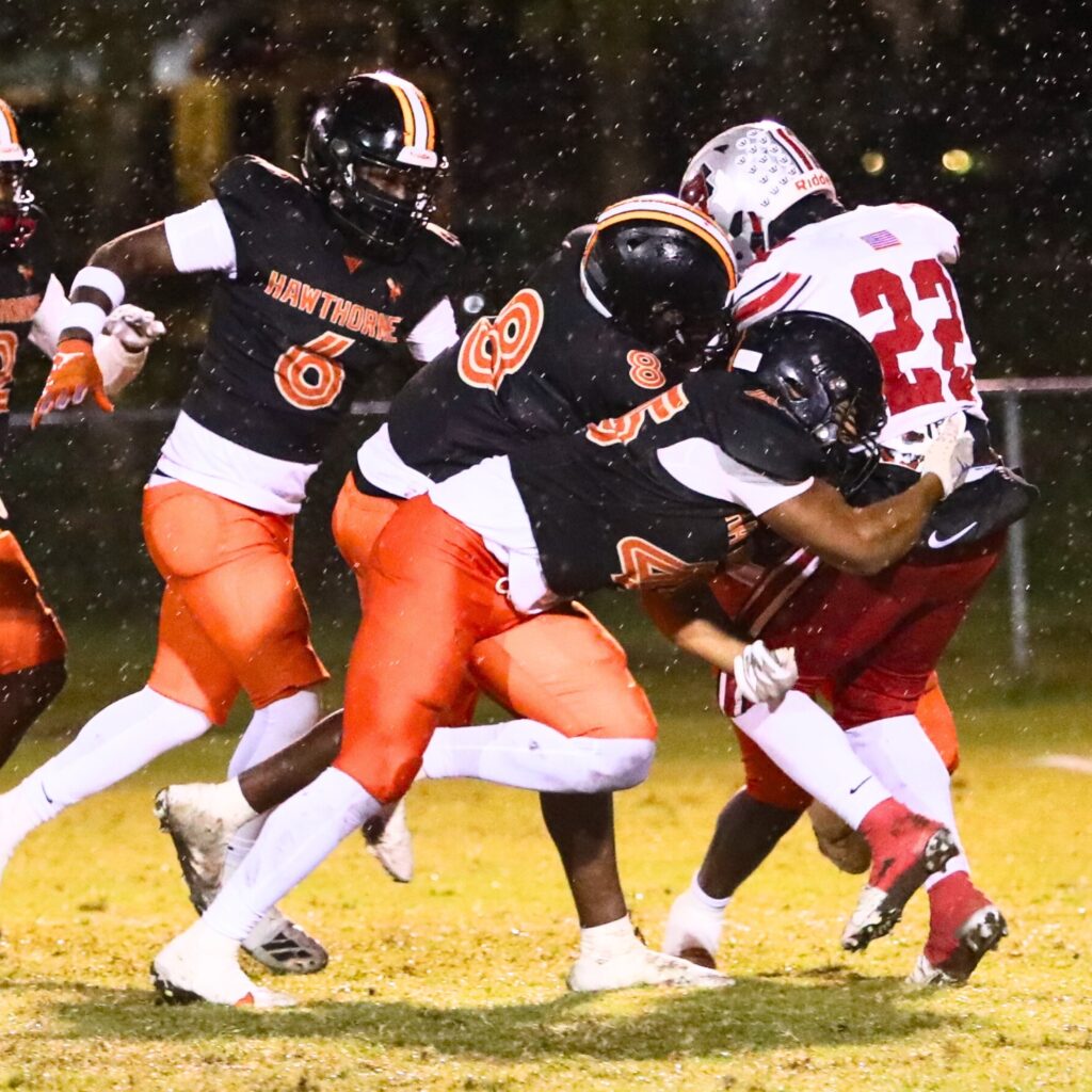 Hawthorne's Naziy Gent (8) and Jaiden Trengrove (45) stop Williston's Jamari Williams (22) in the first quarter.