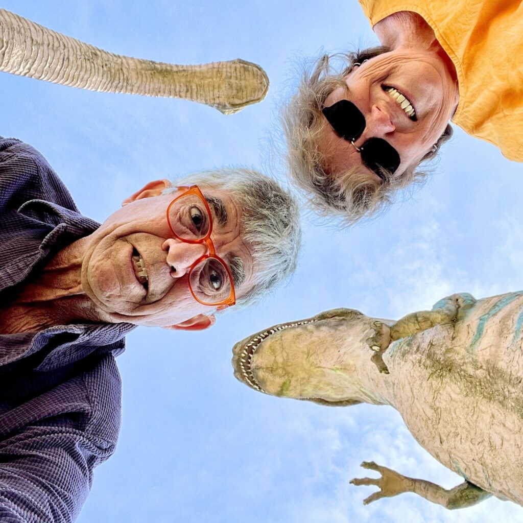 Randy Batista and his wife Linda Lanier pose with dinosaur statues.