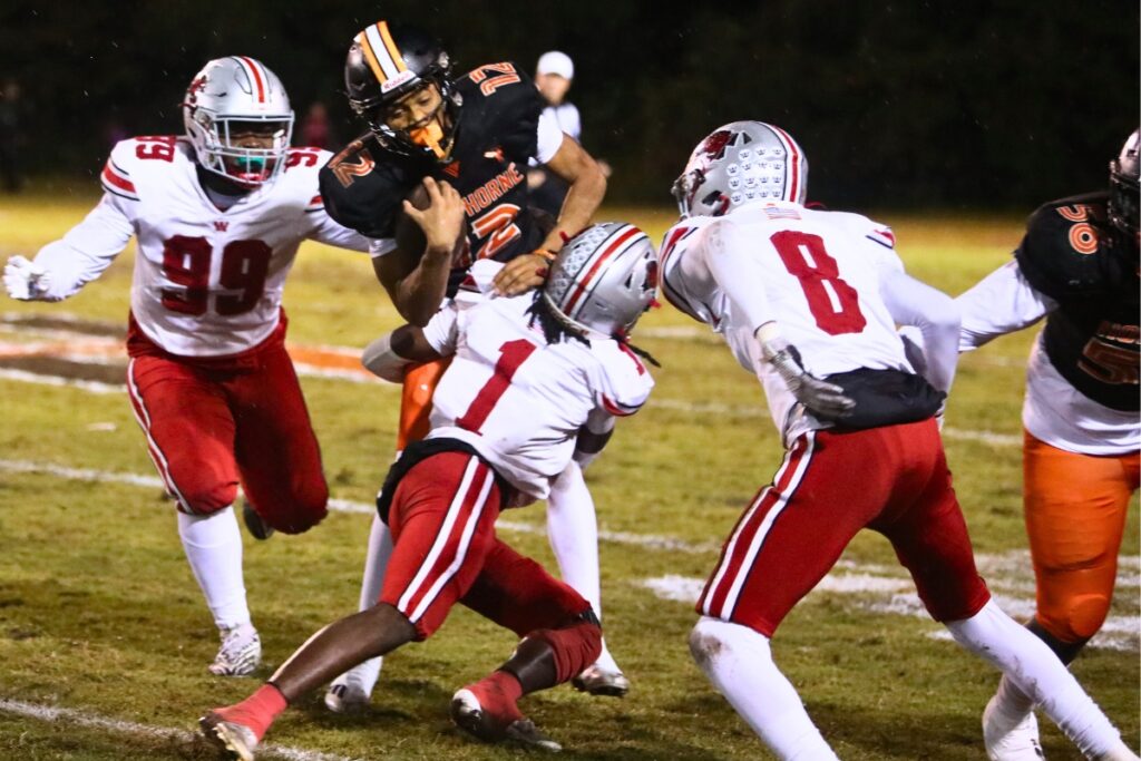 Williston's Ezekiel Taylor (1) tackles Hawthorne's Adrian Curtis (12).