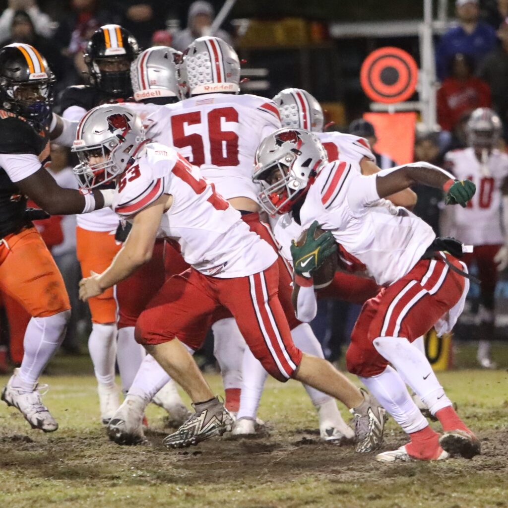 Williston's Omarian Walker (0) looks for room to run against Hawthorne.