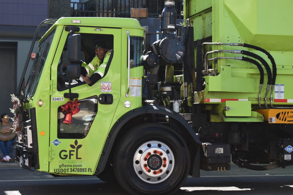 A GFL employee waves from his truck.