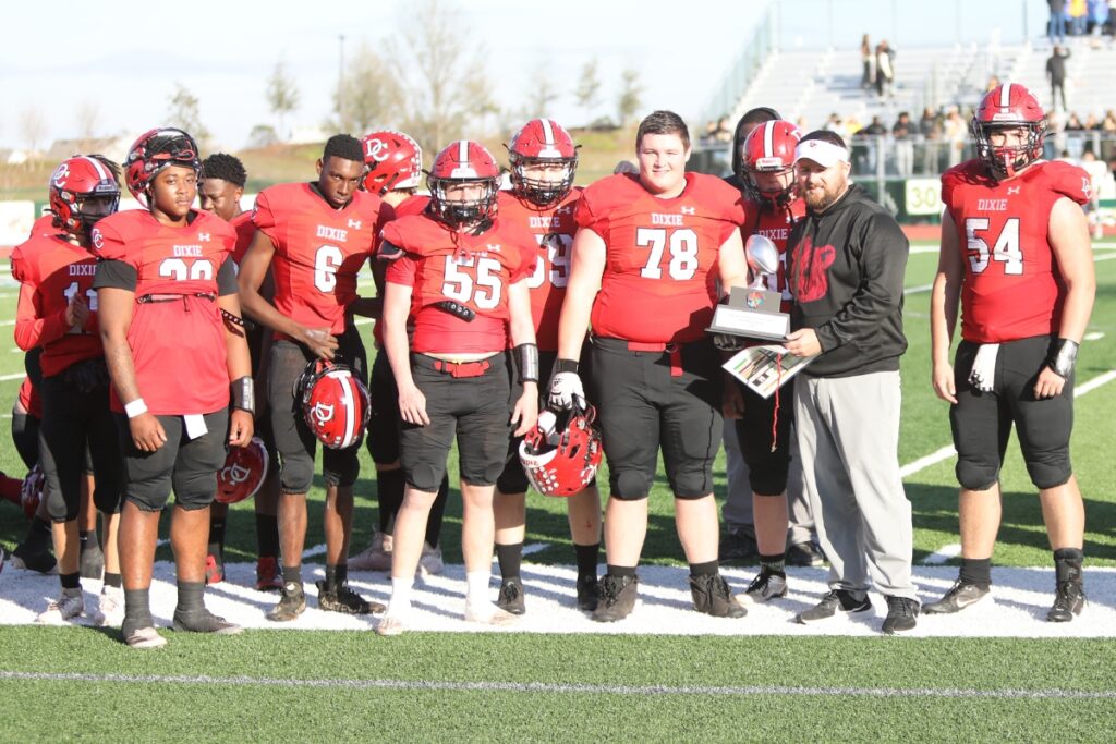 Dixie County coach Ric Whittington holds the Florida Rural Invitational Tournament championship runner up trophy.