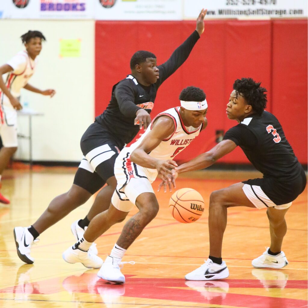 Hawthorne's Dacarion Debose (3) tries to steal the ball from Williston's De'Andre Harvey (5). Photo by C.J. Gish