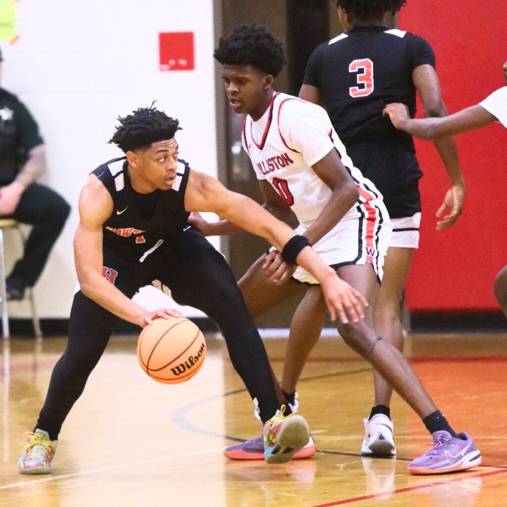 Hawthorne's Leland Johnson (1) gets around a Davion Pugh (33) screen set against Williston's Joel Washington (0). Photo by C.J. Gish