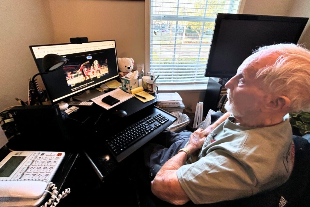 Larry Jaffe sitting in front of his computer watching the Gators basketball game. Photo by Ronnie Lovler