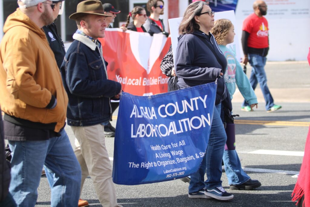 Members of the Alachua County Labor Coalition march down E. University Avenue in the annual MLK Day Parade. Photo by Lillian Hamman