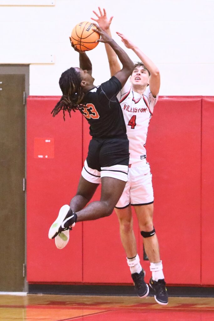 Williston's Adam Henderson (4) blocks a shot by Hawthorne's Davion Pugh (33). Photo by C.J. Gish
