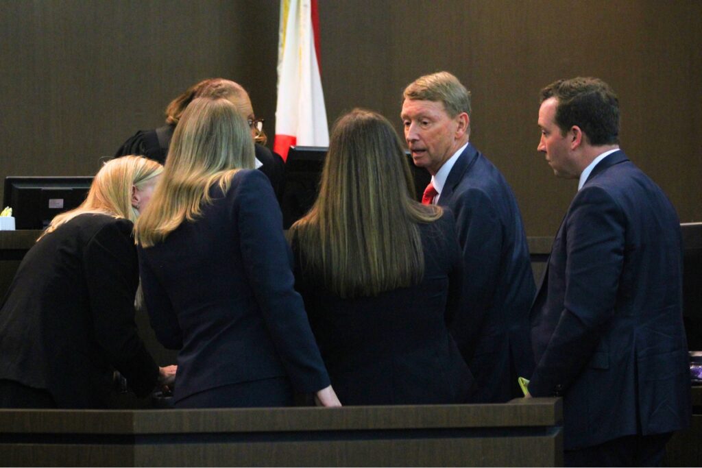 Attorneys for the plaintiff and defendant gather at the bench following an objection during opening arguments. Photo by Seth Johnson