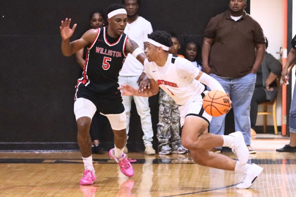 Hawthorne's Leland Johnson (1) drives against Williston's De'Andre Harvey (5). Photo by C.J. Gish