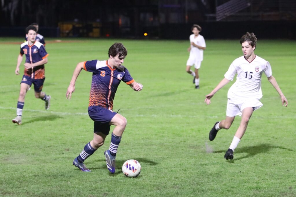 P.K. Yonge's David Demers (6) brings the ball down the field against Williston's Daniel Hughes (15). Photo by C.J. Gish