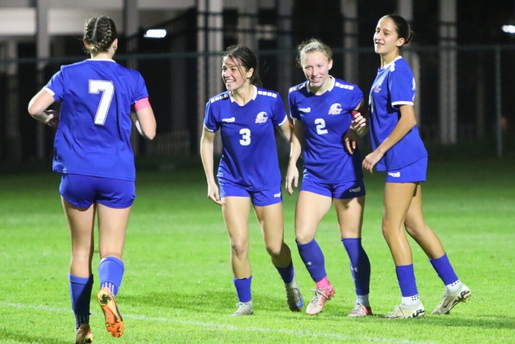 P.K. Yonge's Faith Hardy (2) celebrates with Elliot Pancoast (3) and Bella Young (20) after scoring a goal early in the second half for a 4-0 lead over Maclay (Tallahassee). Photo by C.J. Gish