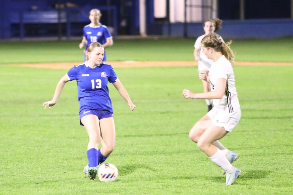 P.K. Yonge's Paige Hegland (13) brings the ball down the field againt Maclay (Tallahassee). Photo by C.J. Gish