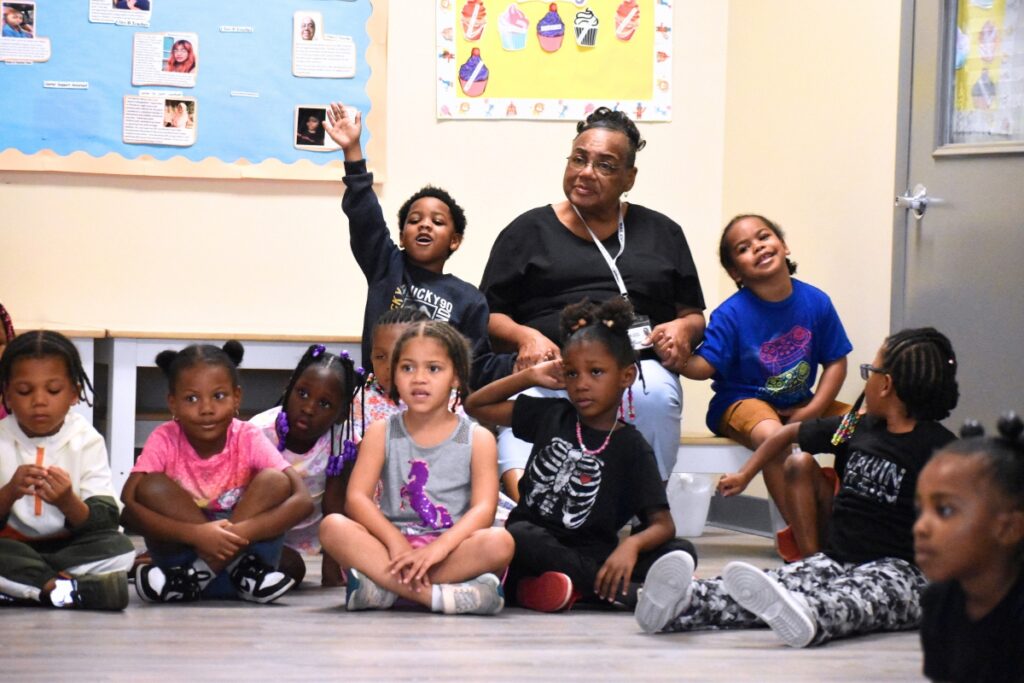 Students raise their hands to tell what they learned from the book. Photo by Glory Reitz