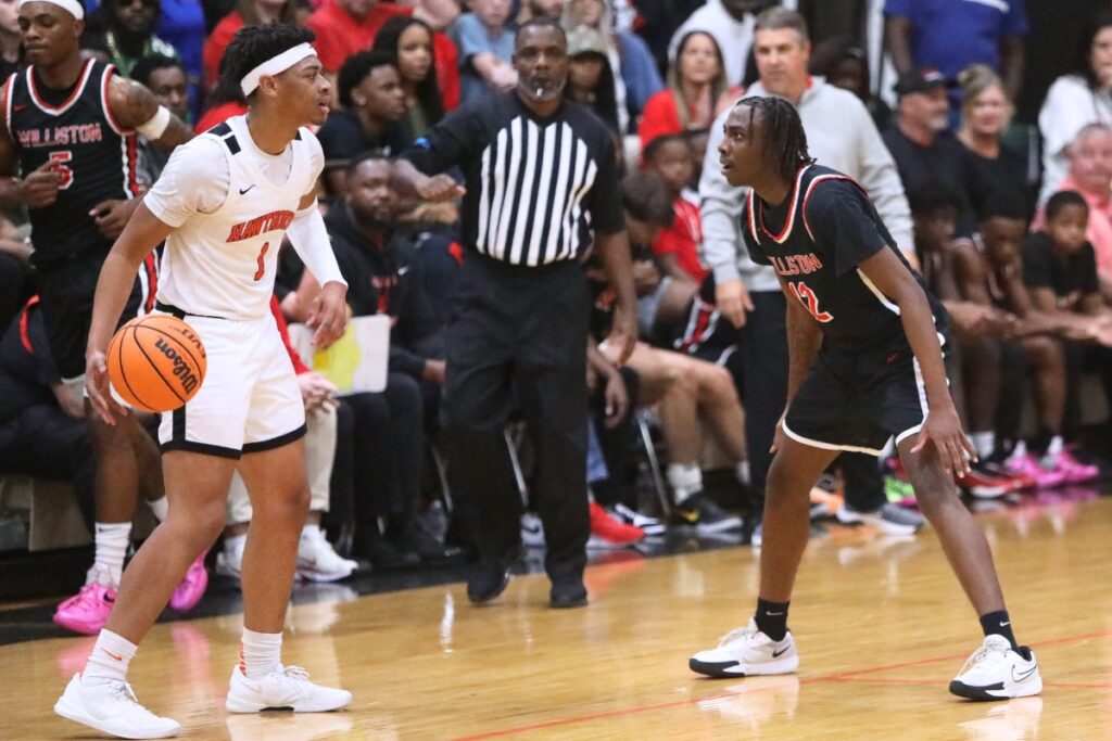 Williston's Azyron Johnson (12) defends Hawthorne's Leland Johnson (1). Photo by C.J. Gish