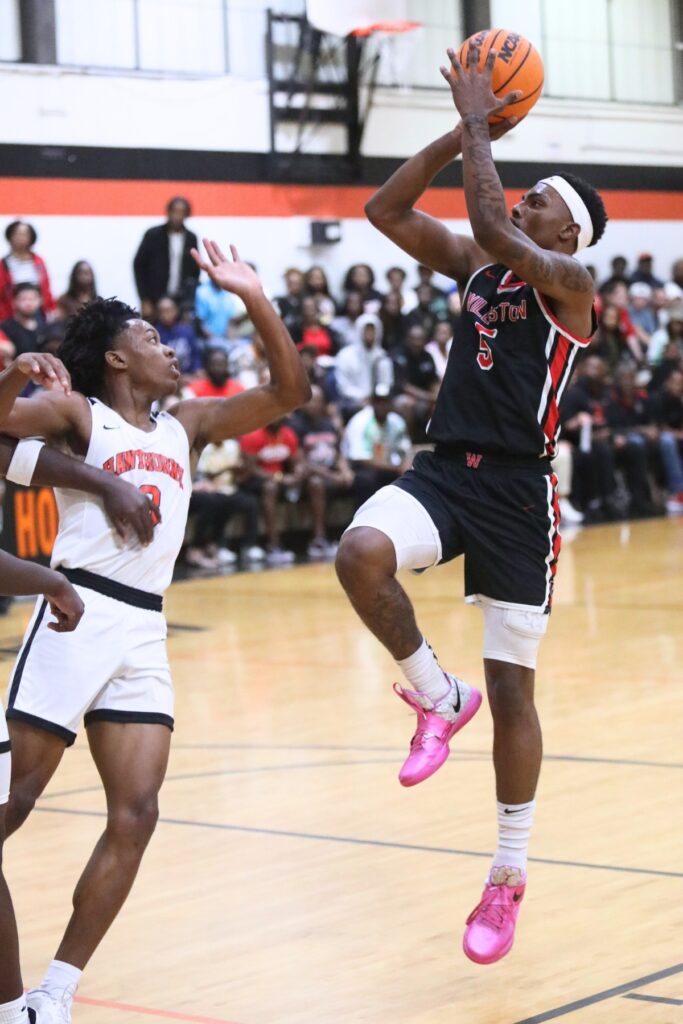 Williston's De'Andre Harvey (5) attempts a shot against Hawthorne's Decarion Debose (3). Photo by C.J. Gish