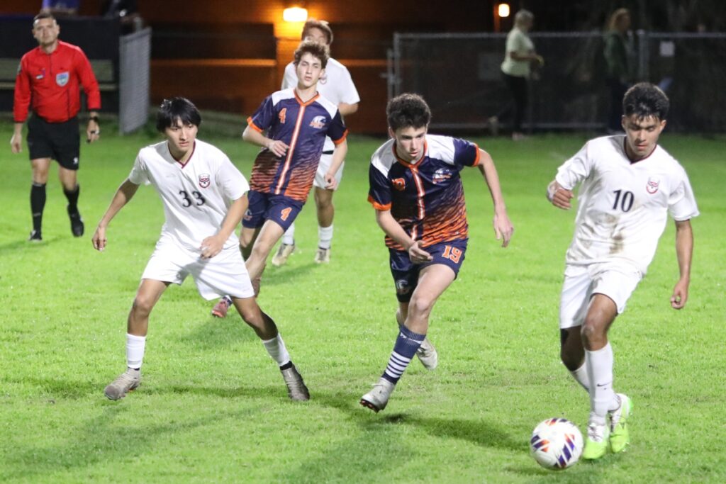 Williston's Miguel Gutierrez (10) goes after the ball in front of P.K. Yonge's Fisher Cooper (19). Photo by C.J. Gish