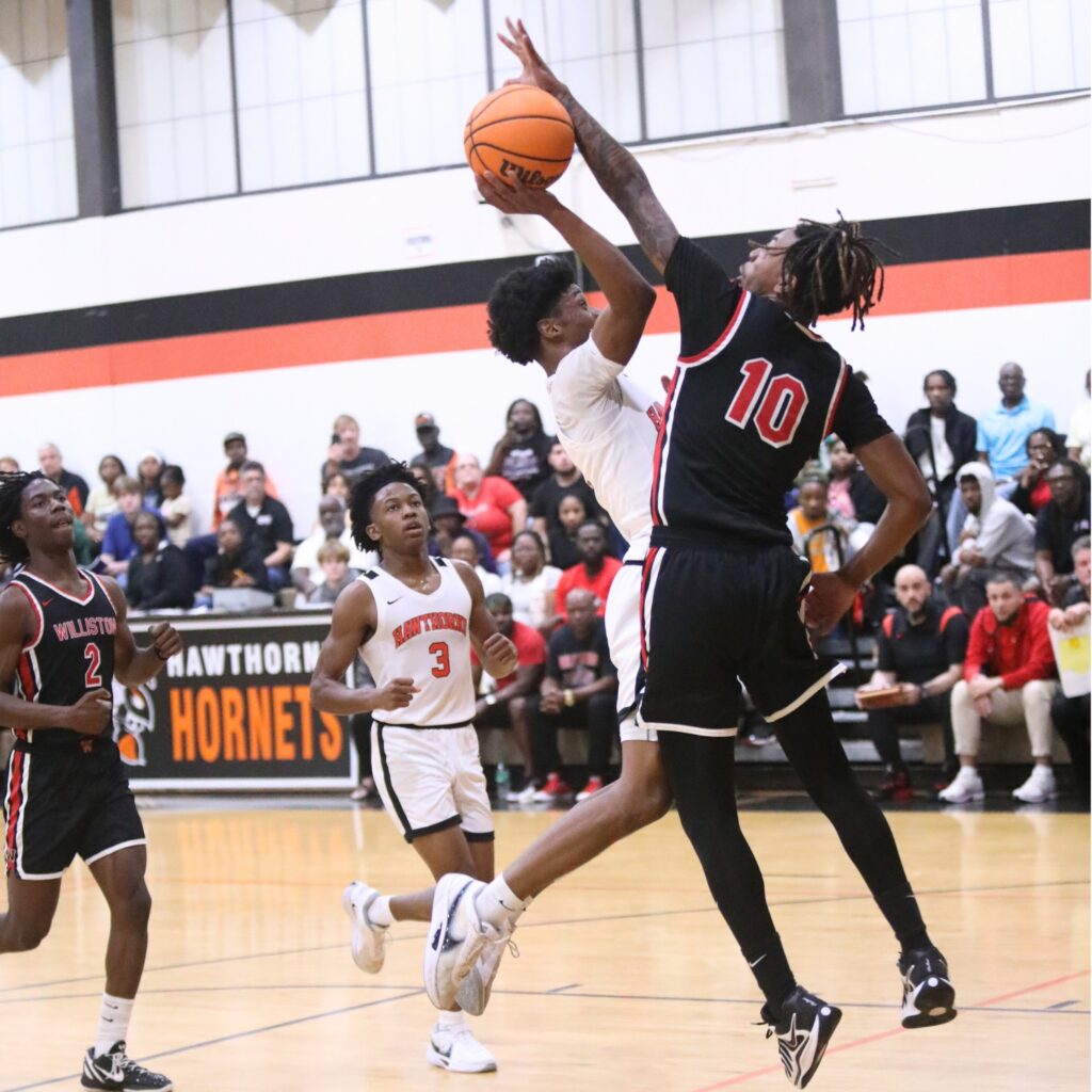 Williston's Xavier Kirkpatrick (10) blocks a shot attempt by Hawthorne's Kelvin Baker (2). Photo by C.J. Gish
