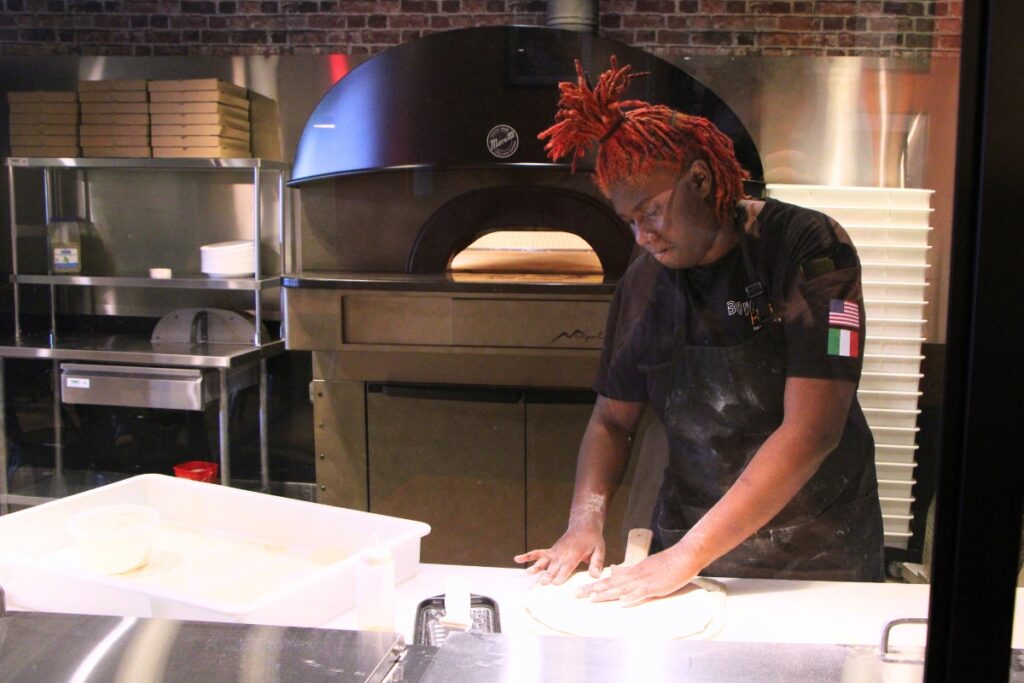 A Bowie Pizza employee prepares dough to make a pizza. Photo by Lillian Hamman